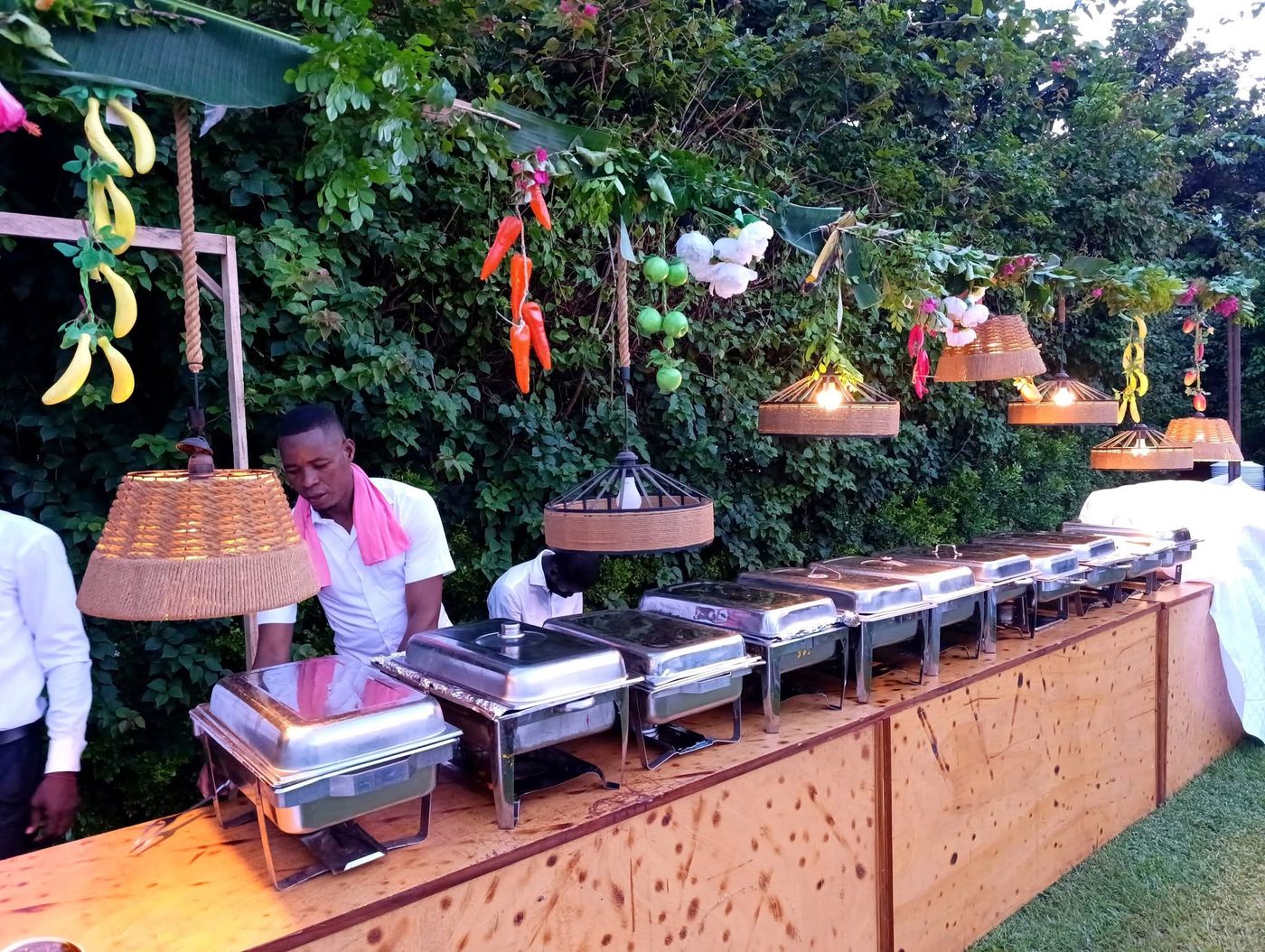 Buffet de grillades installé sous des lanternes en osier dans le jardin
